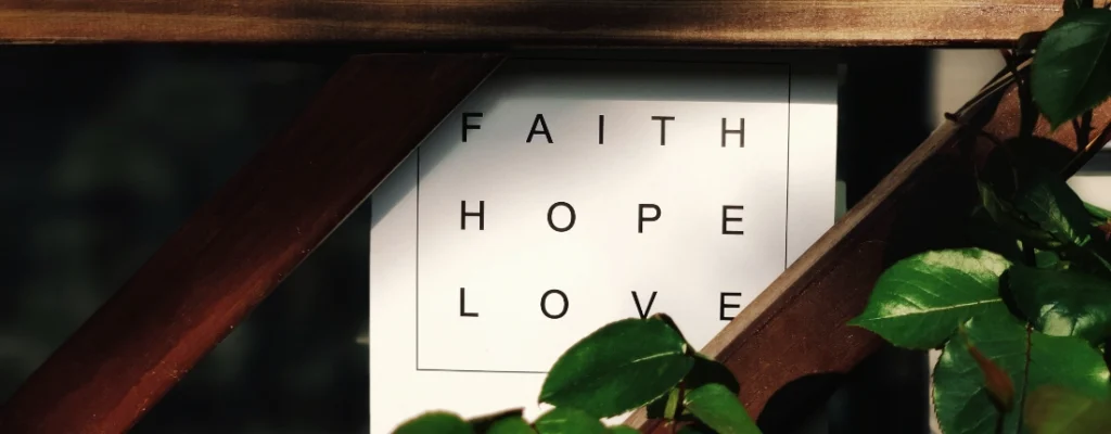 Faith Hope Love banner surrounded by wood trellis and green ivy