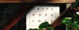 Faith Hope Love banner surrounded by wood trellis and green ivy